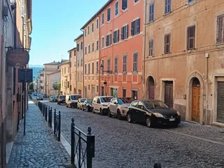 Via Borgo Mario Theodoli: il selciato in sampietrini e le facciate colorate dei palazzi che si allineano lungo la strada.