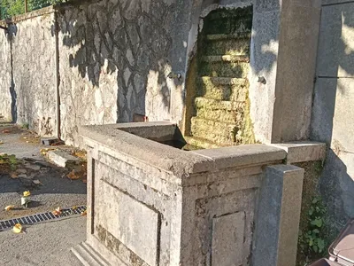 La Fontana Nova lungo Viale Trento Trieste: un fontanile in pietra con la nicchia ad arco e la vasca.