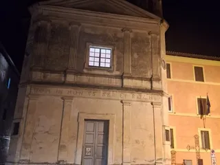 La facciata della chiesa dei Santi Sebastiano e Rocco di sera, con il palazzo comunale sulla destra.