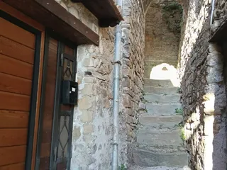 La scaletta di pietra del vicolo, tra i muri antichi e un vecchio portone di legno.