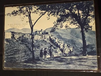 Cartolina d'epoca: "S. Vito Romano - Stazione climatica (m. 700 s. m.) - Panorama da levante", con tre bambini per mano sulla strada e il paese sullo sfondo.