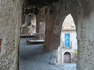 Passaggio coperto con volte in pietra, affacciato su un altro scorcio del borgo. Prenderemo ora queste scale sulla destra e scendiamo verso Piazza San Biagio
