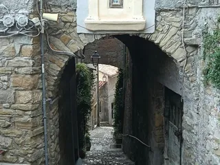 Piccola edicola sacra sopra l'arco d'ingresso a un vicolo in discesa.