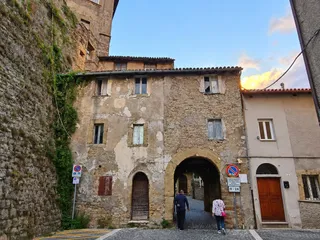 L'arco d'ingresso al quartiere medievale, tra le case in pietra, sulla strada verso Piazza San Biagio.