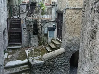 Corte interna con una vecchia vite rigogliosa e una scala esterna. Scendendo le Scale per raggiungere Piazza San Biagio