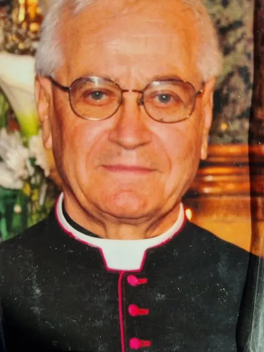 Don Marcello Schiavella in un ritratto degli ultimi anni, con la talare e i fiori dell’altare alle spalle.
