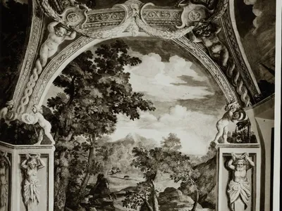Fotografia d'archivio in bianco e nero di un affresco degli interni: un paesaggio con cacciatori e cani, incorniciato da putti, festoni e telamoni dipinti.