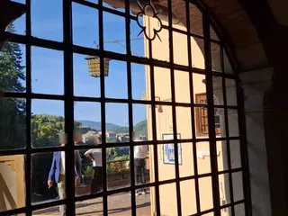 Il paese e le montagne visti attraverso una grata del portico.