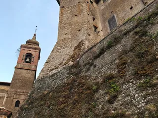 Il castello visto dal basso: la torre in pietra e le mura a scarpa che poggiano sulla rupe, con accanto il campanile in mattoni della Chiesa di Santa Maria de Arce.