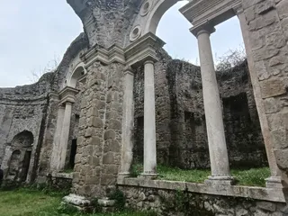 Gli archi incrociati e le colonne del ninfeo, viste dal basso tra le rovine.