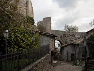 La salita acciottolata verso la Rocca dei Colonna, con le mura della fortezza che sovrastano le case del borgo.