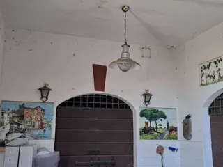 Il loggiato con i portoni ad arco e i pannelli in maiolica dipinta.