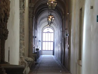Un lungo corridoio voltato, illuminato da lanterne, all'interno della villa.
