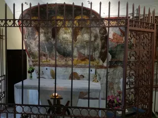 La cappella con l'affresco delle Tre Persone della Trinità, dietro la cancellata.