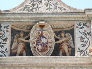 Lo stemma estense sorretto da due angeli, in mosaico e stucco colorato.