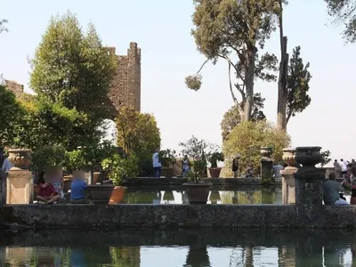 Una delle Peschiere, con alti cipressi e un'antica torre sullo sfondo.