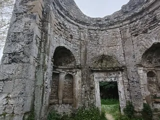 L'interno del ninfeo, con le nicchie absidate invase dalla vegetazione.