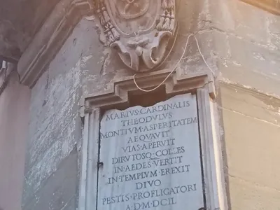 L'iscrizione del cardinale Mario Theodoli all'angolo della piazza, sormontata dallo stemma.