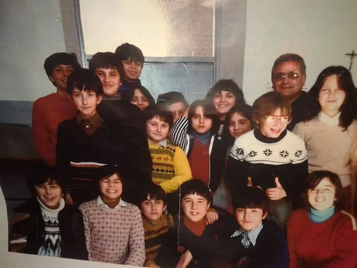 Don Marcello, sulla destra, con un gruppo di ragazze e ragazzi della parrocchia in una foto d’epoca.