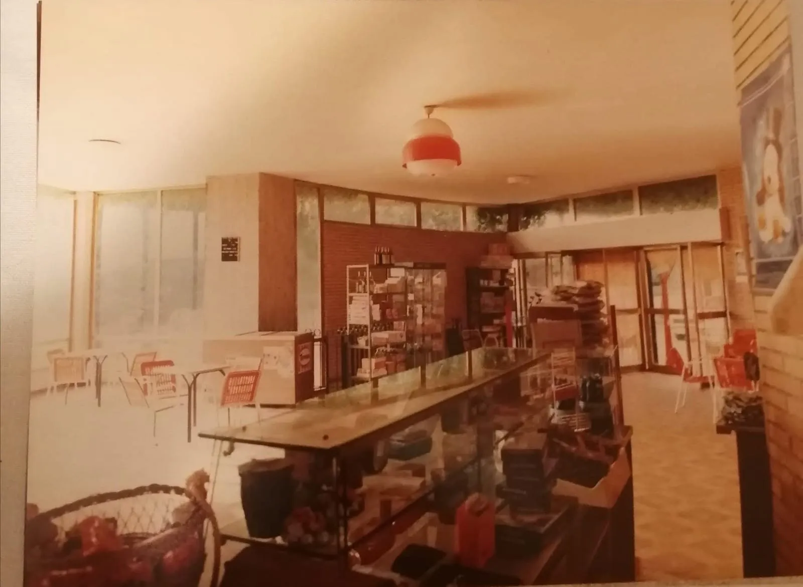 Il bancone con la vetrina dei dolciumi e, sullo sfondo, la sala con i tavolini.