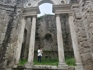 Una visitatrice tra le colonne del loggiato, che restituisce la scala monumentale del ninfeo.