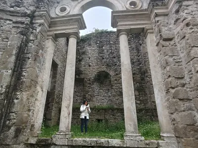 Una visitatrice tra le colonne del loggiato, che restituisce la scala monumentale del ninfeo.