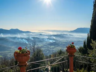 Dal balcone, nel freddo del mattino: la valle punteggiata dalle colonne di fumo dei falò di potatura.